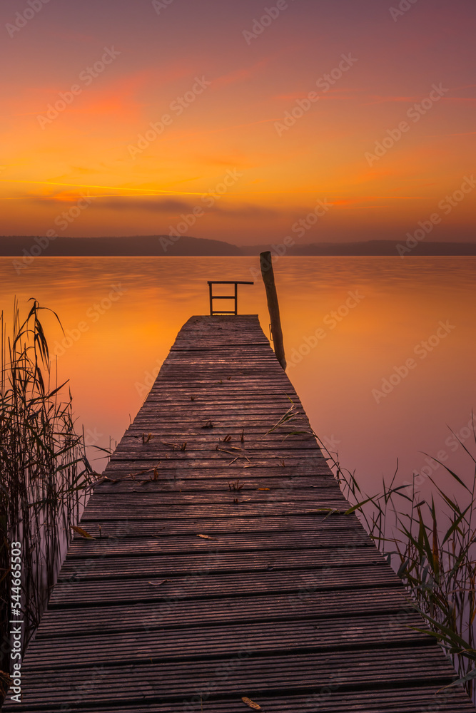 Fototapeta premium Sonnenaufgang über einem Bootssteg am Ufer des Plauer Sees in Plau am See in der Mecklenburgischen Seenplatte