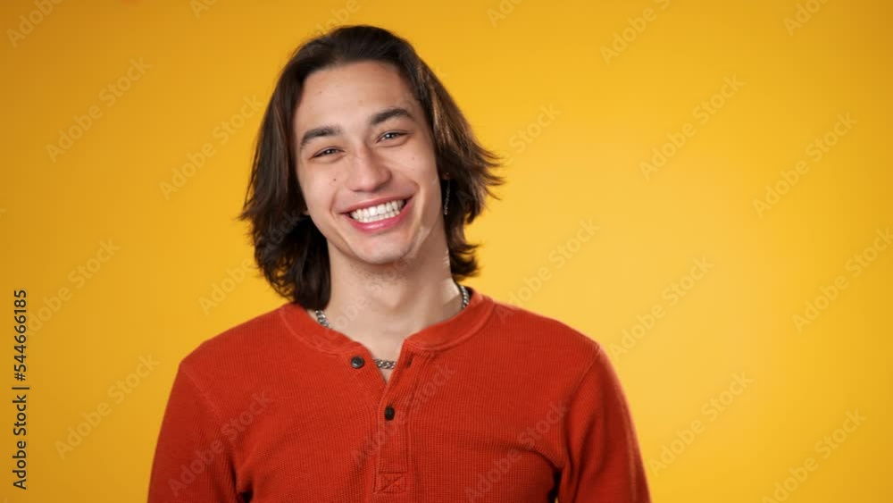 Silly, goofy, funny face of Hispanic gender fluid young man 20s posing isolated on yellow background studio. Silly, goofy, funny face of Hispanic gender fluid young man 20s posing isolated on yellow background studio.