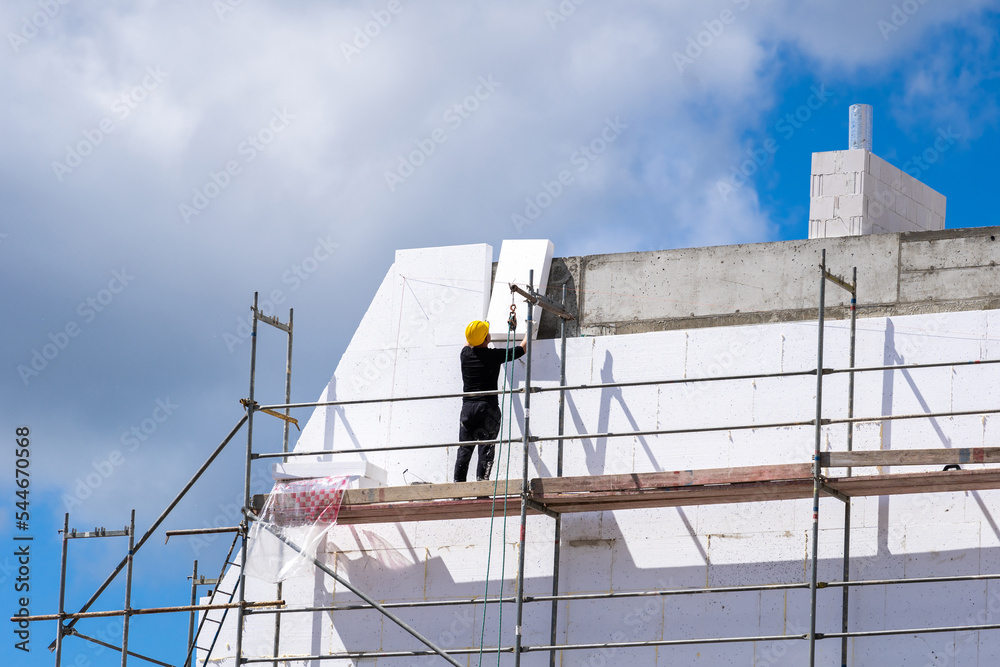 Φωτογραφία Man installing styrofoam sheets on house facade wall for thermal protection