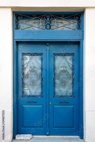 Old-fasioned blue wooden front door with metal grates 