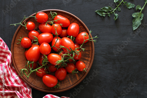 cherry tomatoes on a clay bowl, top view. ripe fresh vegetables. copy space.