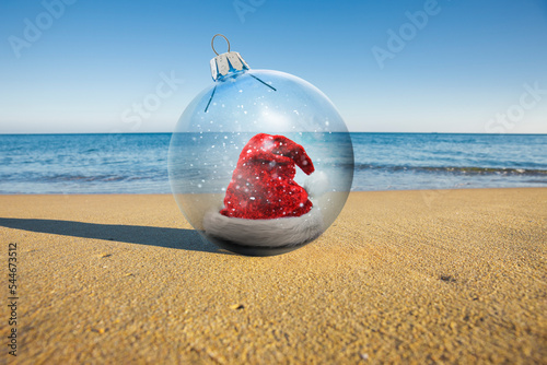Weihnachtsmütze am Sandstrand mit Meer im Hintergrund