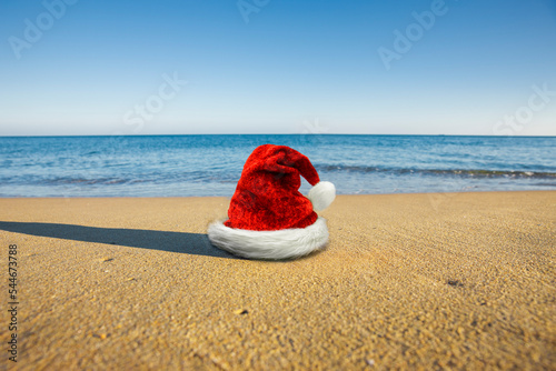 Weihnachtsmütze am Sandstrand mit Meer im Hintergrund