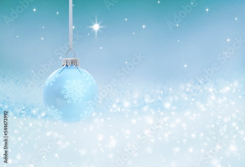 Blaue gläserne Weihnachtskugel vor blauem Hintergrund