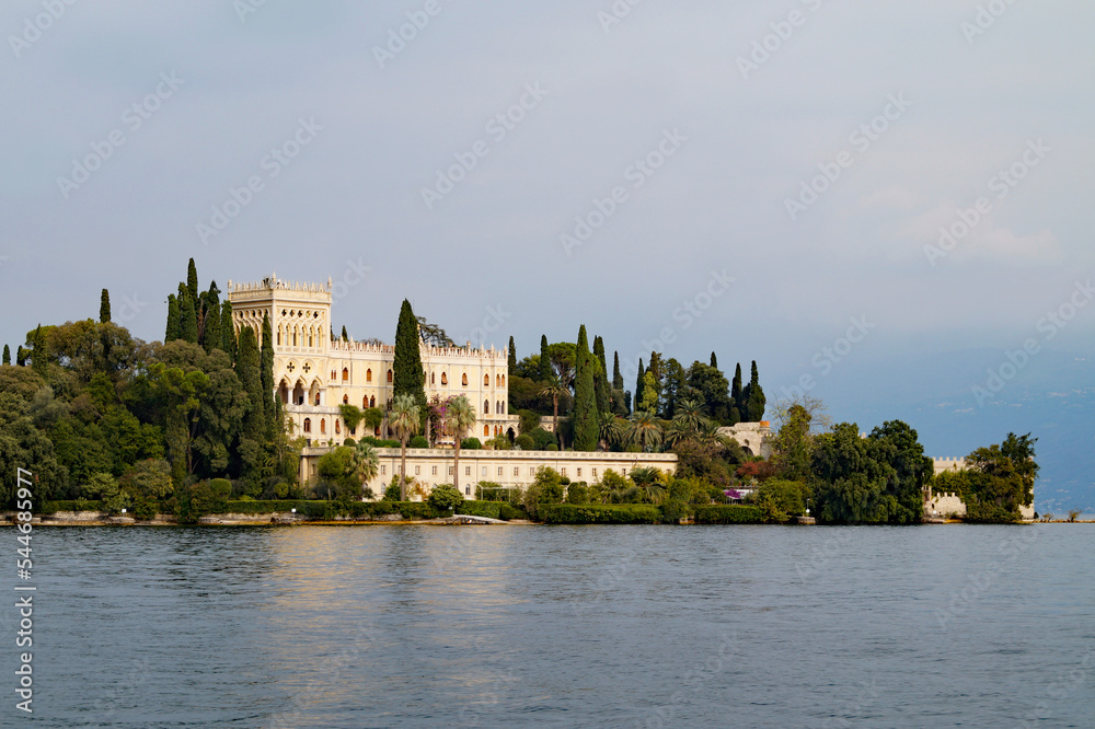gorgeous mediterranean castle with a park full of beautiful exotic tropical trees and plants on Isola del Garda or Isola di Garda or Isola Borghese on lake Garda, Lombardy, Italy