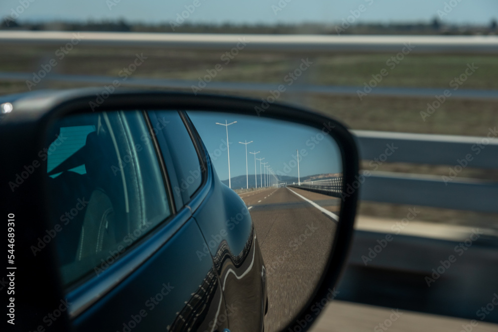 Car right side mirror on Portuguese highway, road landscape view on the car side mirror.