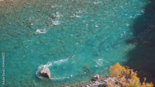 4K shot of the blue Tsarap River flowing besides the Phugtal monastery in Zanskar Valley in Ladakh, India. Natural background. Clear water of the river besides the Phuktar gompa. Blue river in Zanskar photo