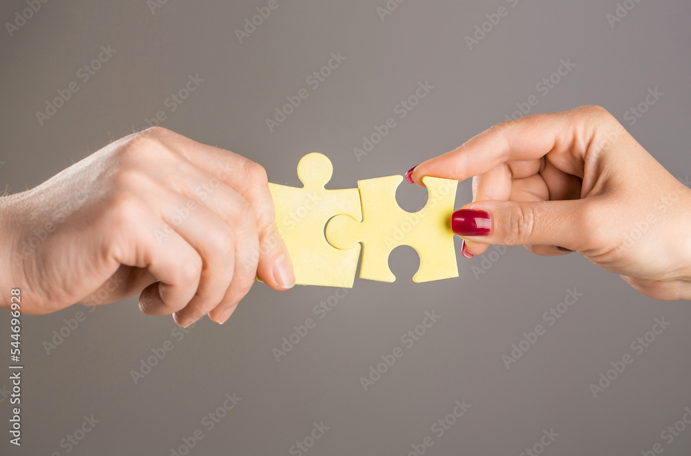 Hands connecting puzzle. Puzzles. Hand of the child and hand of mother fold  puzzle, closeup. Hands hold puzzles. Solution of problems. Mens and childs  hands connecting puzzles Stock-Foto | Adobe Stock