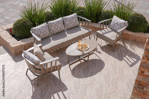 Φωτογραφία comfortable leisure sofa with cushions and table in a green garden during sunny