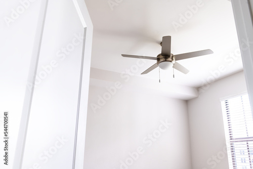 Empty bedroom room interior nobody looking up at ceiling fan open door in new modern luxury apartment home house with window bright light