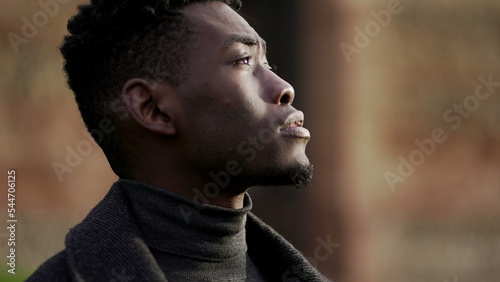 African young black man standing at park looking up in contemplation2