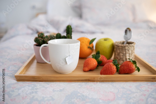 breakfast tray in bed, with fruit and cup of tea
