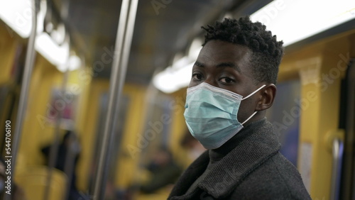 African man standing in subway metro wearing coronavirus mask underground4