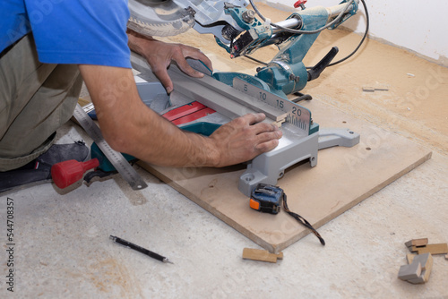 male builder carpenter sawing a circular saw