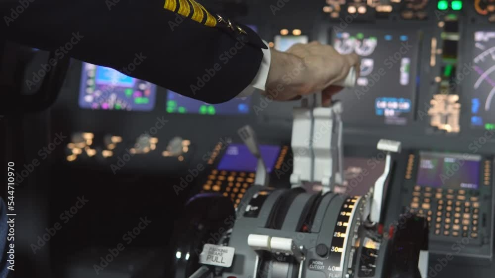 Close up of the pilot hand pressing the gas lever in the cockpit of the jet aircraft throttling engine power during takeoff.