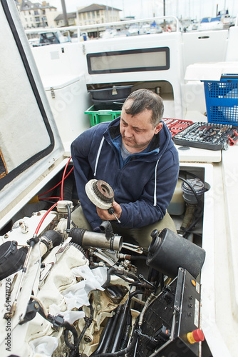 Boat mechanic repairing a ship engine