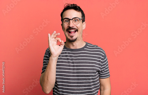 feeling successful and satisfied, smiling with mouth wide open, making okay sign with hand