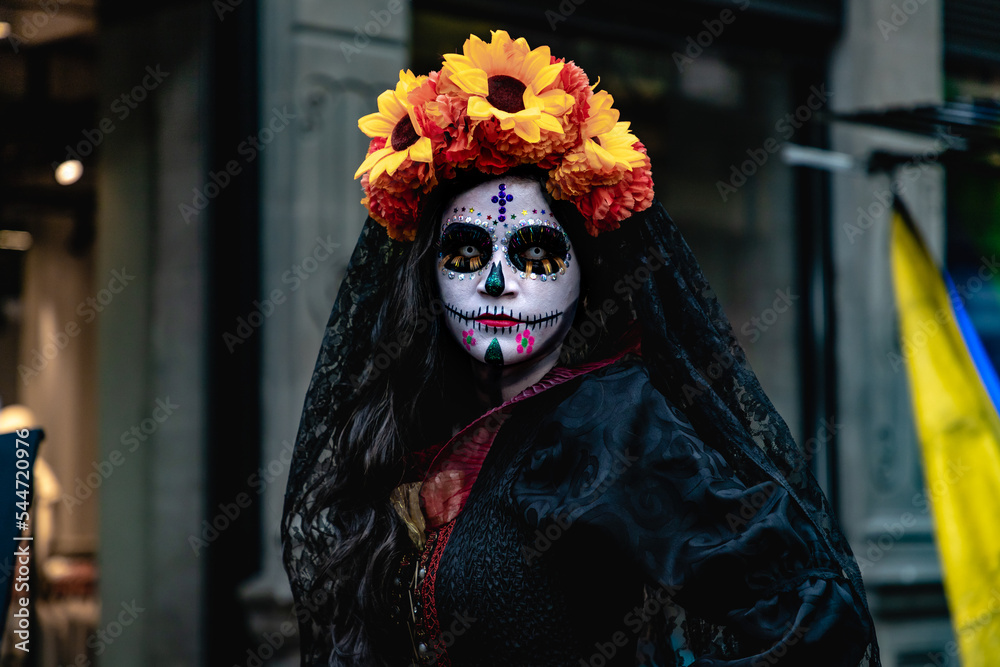 Mujer disfrazada de catrina con velo negro y arreglo floral en la cabeza,  en calles del centro histórico de la ciudad de México. Photos