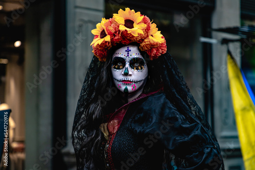 Mujer disfrazada de catrina con velo negro y arreglo floral en la cabeza, en calles del centro histórico de la ciudad de México. 