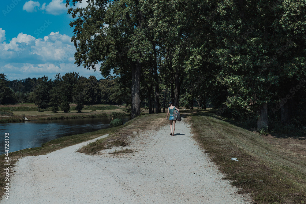 woman on the park path near the river woman on the park path near the river