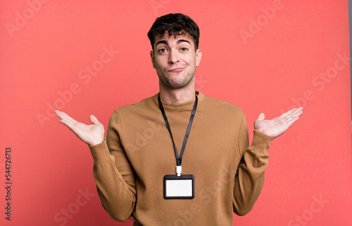 adult man feeling puzzled and confused and doubting with an acccess identity card photo