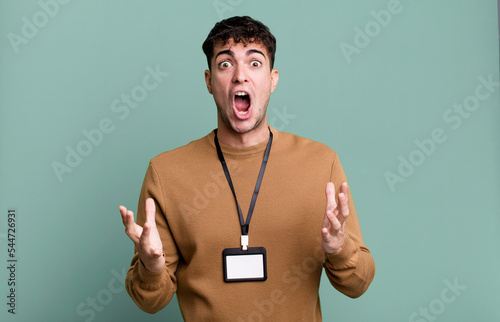 adult man amazed, shocked and astonished with an unbelievable surprise with an acccess identity card photo