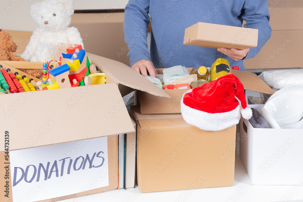 Christmas donations for charity. Man volunteer collecting food, clothes
