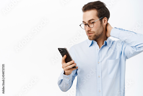 Billede på lærred Portrait of busy businessman looking troubled at his mobile phone, reading on sm