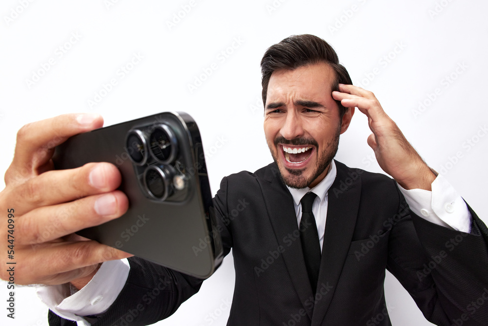 Man businessman holding the phone in his hand looking at him. Headache and anger from failure stress. Close-up wide angle photo white isolated background Man businessman holding the phone in his hand looking at him. Headache and anger from failure stress. Close-up wide angle photo white isolated background