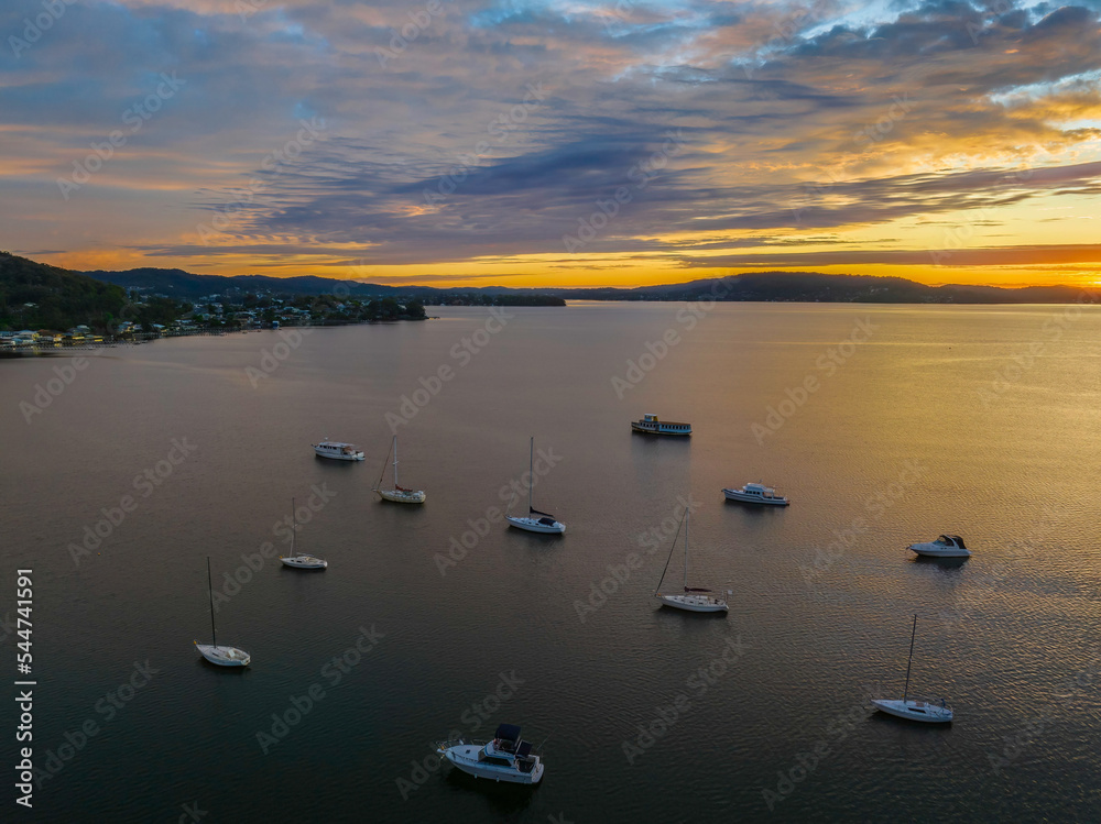 Fototapeta premium Aerial sunrise over the bay with boats and clouds