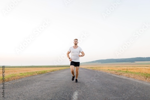 Active man jogging on road