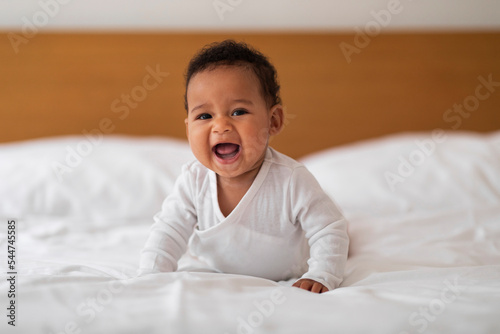 Adorable Small Black Baby Crawling On Bed And Laughing