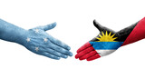 Handshake between Micronesia and Antigua Barbuda flags painted on hands, isolated transparent image.