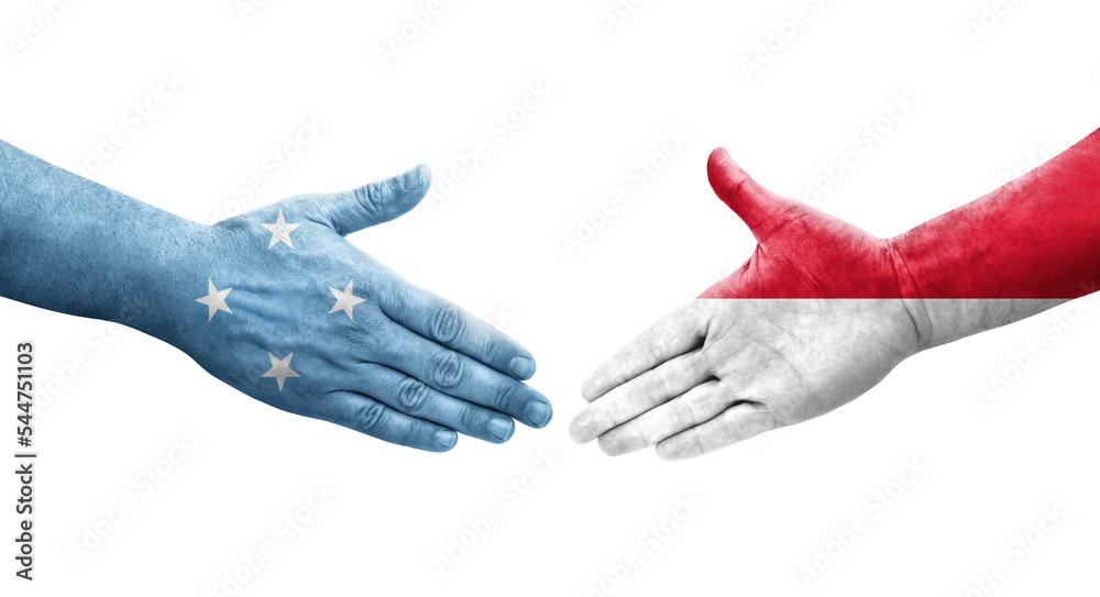 Handshake between Micronesia and Monaco flags painted on hands, isolated transparent image.