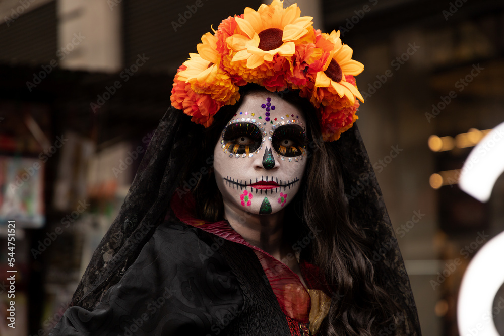 Mujer disfrazada de catrina con velo negro y arreglo floral en la cabeza,  en calles del centro histórico de la ciudad de México. foto de Stock
