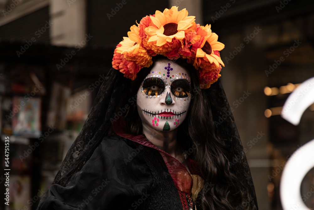Mujer disfrazada de catrina con velo negro y arreglo floral en la cabeza,  en calles del centro histórico de la ciudad de México. Photos