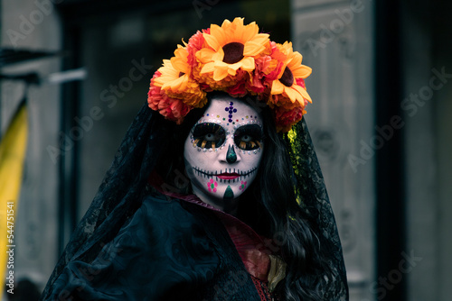 Mujer disfrazada de catrina con velo negro y arreglo floral en la cabeza, en calles del centro histórico de la ciudad de México. 