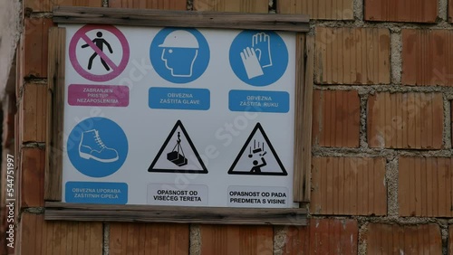 A plate on the observance of precautionary measures. Construction work in progress. Safety signs. Danger warnings for passers-by. Lettering in Croatian. Rovinj, Istria, Croatia - November 9, 2022