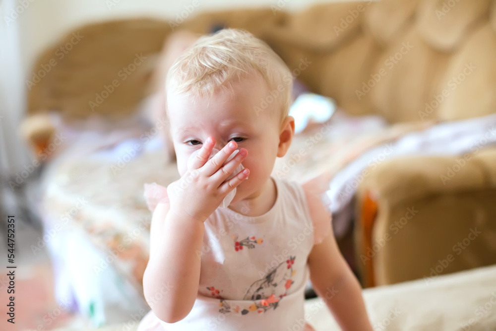 The baby pulls out her nose with her nose during a runny nose. A sick child learns to get out. A beautiful girl with a cold and viral rhinitis. The baby pulls out her nose with her nose during a runny nose. A sick child learns to get out. A beautiful girl with a cold and viral rhinitis.