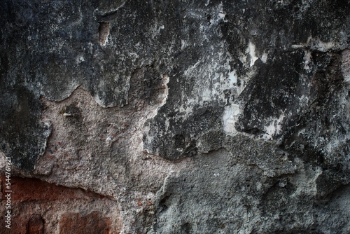 background concept using old cracked wall material, peeling wall surface forming abstract art, old wall background full of cracks and moss