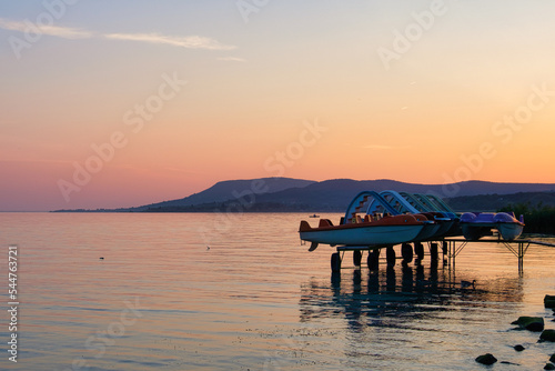 Parking water bikes at dusk on the Csasztai Beach of Lake Balaton - Revfulop, Hungary photo