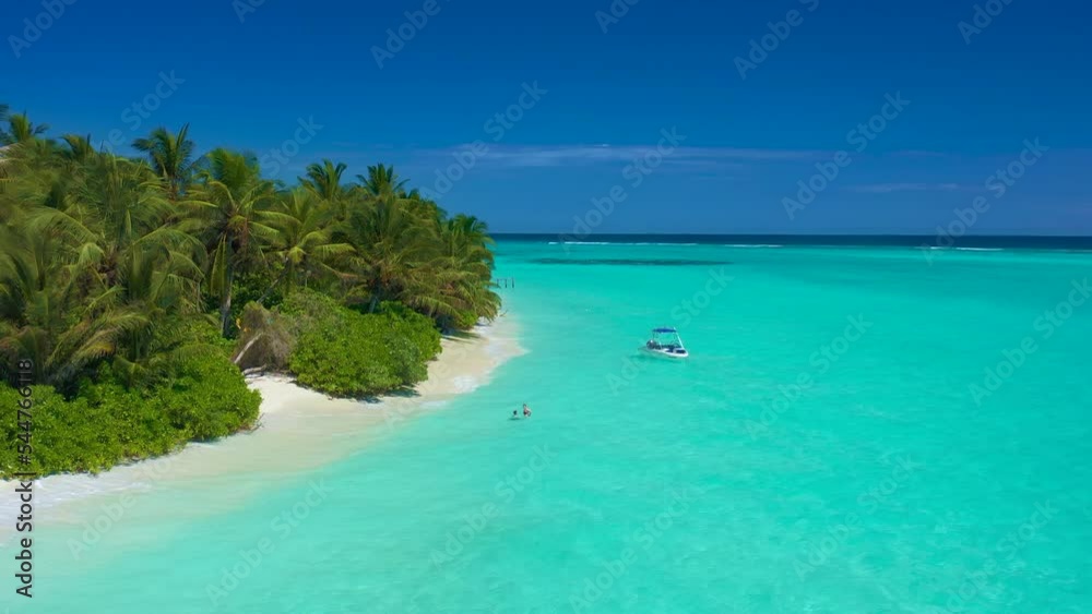 Paradise white sand beach, turquoise ocean, green palm trees and blue sky with clouds on a sunny day in island Thoddoo in Maldives. Summer tropical landscape, aerial panoramic view Paradise white sand beach, turquoise ocean, green palm trees and blue sky with clouds on a sunny day in island Thoddoo in Maldives. Summer tropical landscape, aerial panoramic view