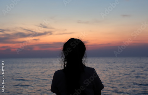 Lonely woman standing on the beach at sunset. Lonely man.
