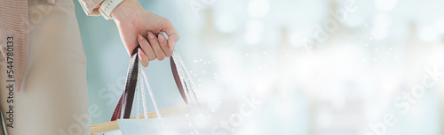 A woman doing grocery shopping at the supermarket, she is leaning in the shopping cart and connecting with her phone, apps and retail ideas. photo