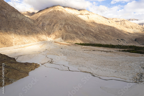 image aerial view of the vast white sand and the mountain behind at Yarab Tso Lake Nubra Valley, Ladakh