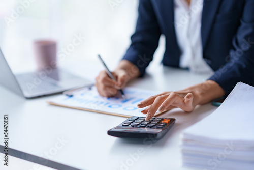 Foto Close-up of the hands of a business woman using a calculator to check financial accounts check the company's expenses and budget