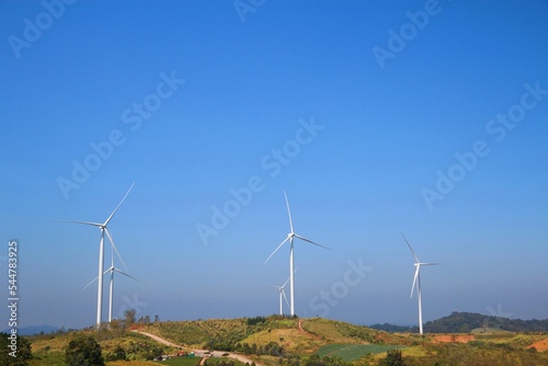 Landscape with hills and wind turbines and blue sky backgound.