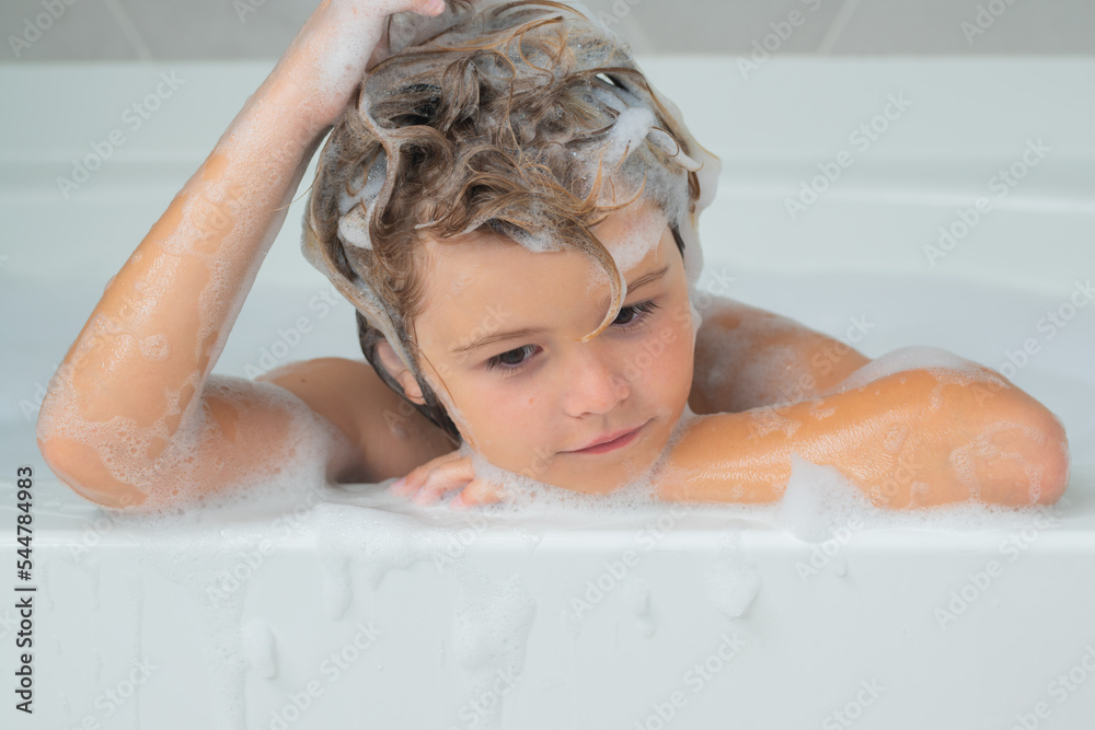 Kids shampoo. Child in the bath with bubbles. Happy child enjoying bath time. Little boy smiling in the bath with soap foam. Child bathes in a bath with foam.