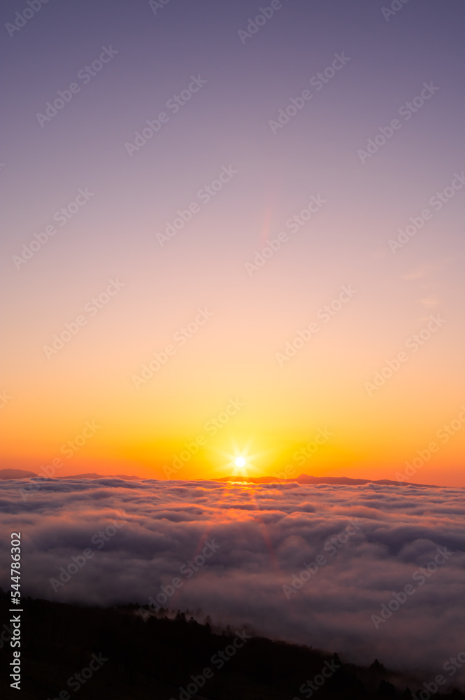 快晴の朝の雲の上に昇る太陽。日本の北海道の美幌峠で。