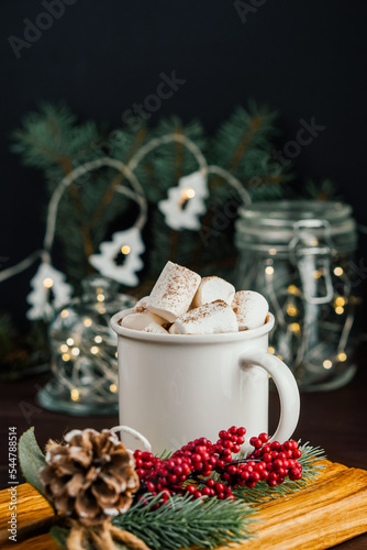 Christmas drink hot chocolate with marshmallows at festive illuminated decoration. Selective focus